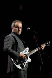 David Arnold performing on stage with the Royal Philharmonic Concert Orchestra at The Sound of 007 at the Royal Albert Hall.